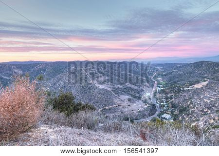 Laguna Canyon Road with Saddleback Mountains in the distance from Top of the World hiking trail in Laguna Beach at sunset