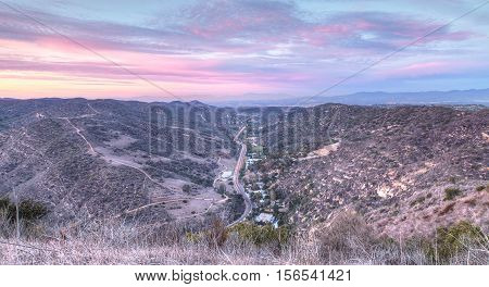 Laguna Canyon Road with Saddleback Mountains in the distance from Top of the World hiking trail in Laguna Beach at sunset