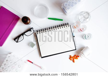 doctor workplace with blank open notebookat lab top view on white background