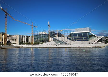 OSLO NORWAY - AUGUST 17 2016: Tourist on the Oslo Opera House which is home of Norwegian National Opera and Ballet and National Opera Theatre in Oslo Norway on August 172016.