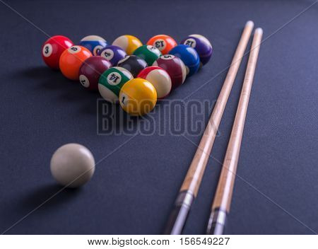 Blue billiard table with balls and cues.