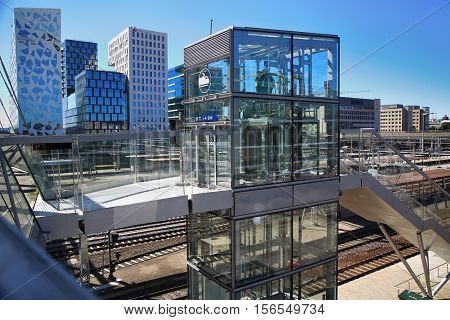 OSLO NORWAY - AUGUST 17 2016: View of Akrobaten pedestrian bridge with modern business architecture and elevator lift that leads to the railway station street in Oslo Norway on August 17 2016.