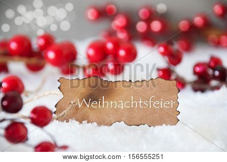 Burnt Label With German Text Weihnachtsfeier Means Christmas Party. Red Christmas Decoration On Snow. Cement Wall As Background With Bokeh Effect. Card For Seasons Greetings