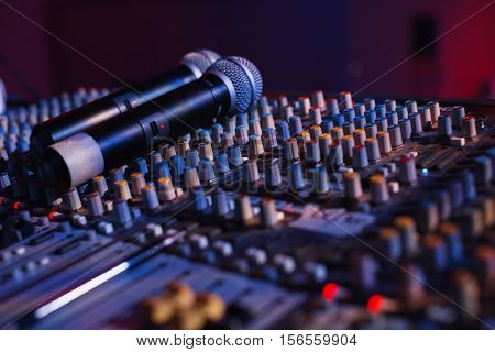 Soundman working on the mixing console in concert hall