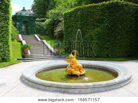 LINDERHOF GERMANY - JULY 8, 2016: A golden fountain in Linderhof Palace garden. Castle in southwest Bavaria near Garmisch Partenkirchen. The Castle built by King Ludwig II of Bavaria in 19th century.