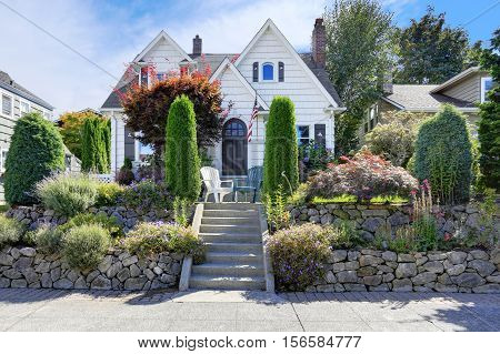American craftsman style home with beautiful landscape design trimmed shrubs rocks and flowers. Northwest USA