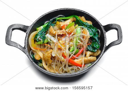 Korean rice noodle with vegetables on frying pan on white background