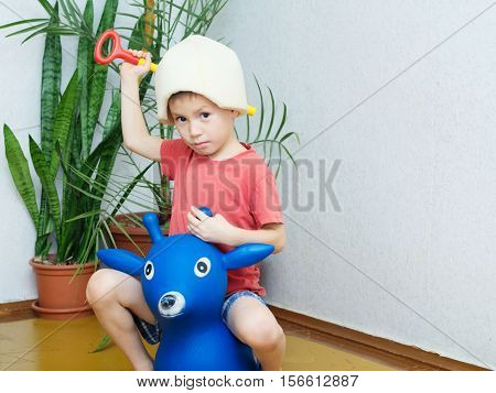 boy playing knight with stick like sword deer like horse and hat like helmet