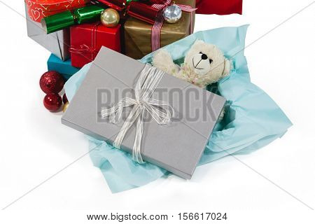 Christmas presents with soft toy and decoration against white background