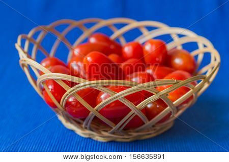 fresh tomatoes in a basket on a blue background