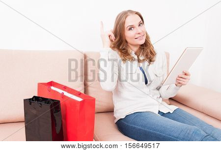 Woman Laying On Chouch Holding Tablet Showing Idea Gesture