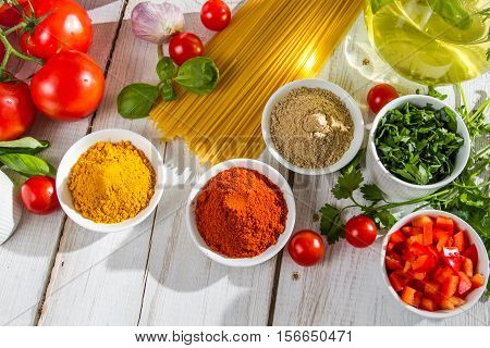 Ingredients and italian cuisine spices on old wooden table