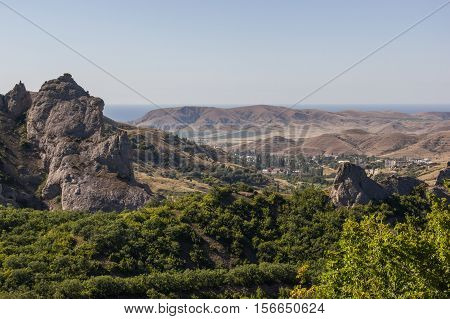 Mountain peaks and hills in the background of the sea.