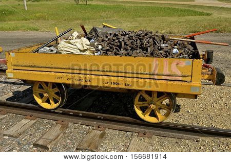 An old railroad cart full of parts for repairing train tracks is loaded for usage