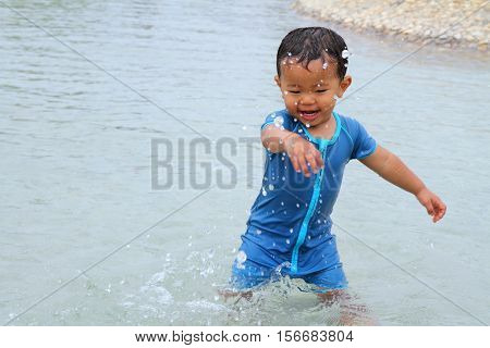 Japanese boy playing with water (1 year old)