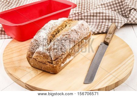 traditional irish sodabread for st. patrick's day on round wooden board with bread knife