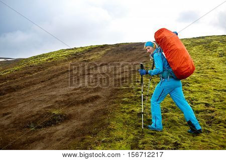 female hiker on the trail in the Islandic mountains. Trek in National Park Landmannalaugar, Iceland