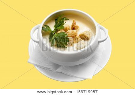 Cheese soup with croutons in a pot with handles