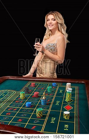 woman in a smart dress plays roulette. addiction to gambling. holding hands in a glass