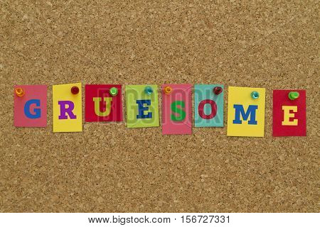 Gruesome word written on colorful sticky notes pinned on cork board.
