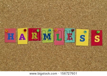 Harmless word written on colorful sticky notes pinned on cork board.