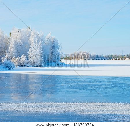 Winter landscape with frozen river and forest in the frost