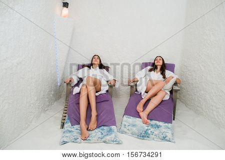 Two happy women relaxing in a SPA Salarium salt cave.