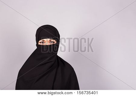 Beautiful Muslim girl wearing black burqa closeup.