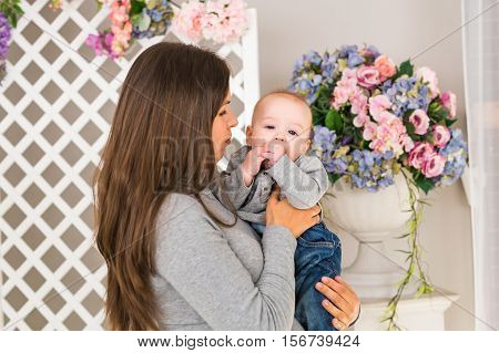 Young mother woman holding and hugging in her arms child baby kid girl smilling laughing.