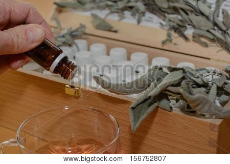 Brown drug bottle over liquid - sage and other medicine bottles in the background