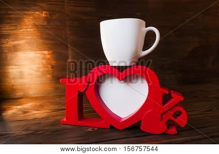 red photoframe with a cup on wooden background