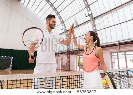 Thank you for set. Positive professioanl tennis players standing near net and giving high five while resting after playing tennis