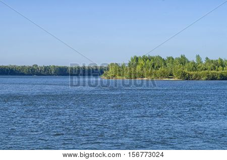 island covered with green forest on a large river