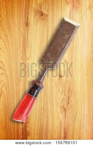 old rusty chisel on wood background .