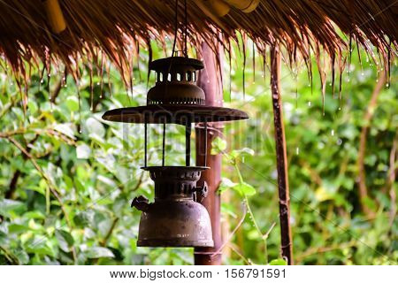 Hurricane lamp is hang under eaves on the raining day.