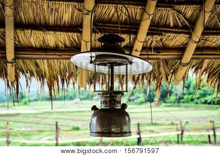 Hurricane lamp is hang under eaves on the raining day.
