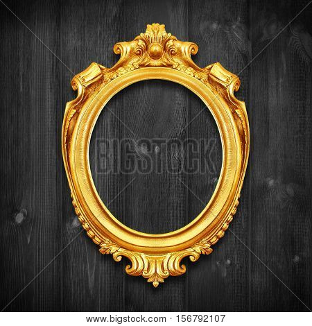 The Antique gold frame on wooden wall;. Empty Antique gold picture frame on wooden wall.