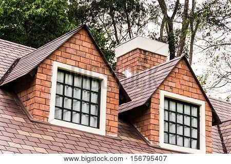 Triangular end of a roof with two windows.