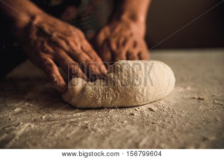 woman knead the dough by hand on pies