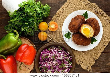 Meat mini-rolls (cutlet) with boiled egg and fresh vitamin salad of chinese cabbage and greens. The top view
