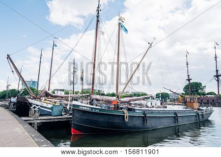 Amsterdam Netherlands - August 1 2016: Old sailing ships moored in the pier near The National Maritime Museum in Amsterdam a cloudy day