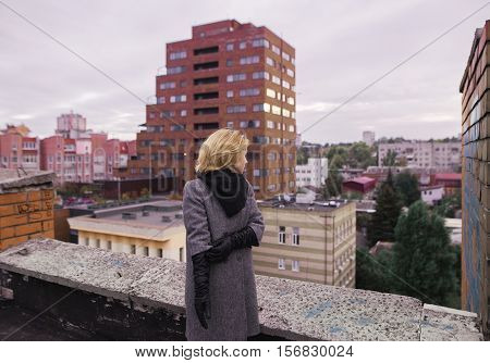 Businesswoman Standing On An Edge Of A Skyscraper's Rooftop