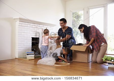 Family Unpacking Boxes In New Home On Moving Day