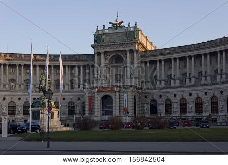 VIENNA, AUSTRIA - DECEMBER 31 2015: View from the street of Hosburg Palace facade in Vienna with cars parked around and few people