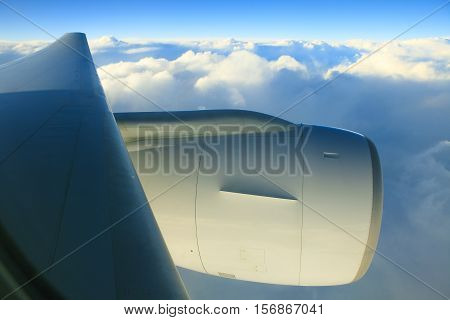 air plane engine and wing floating over white cloud and blue sky
