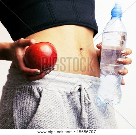 woman measuring waist with red apple and water, african tann isolated close up