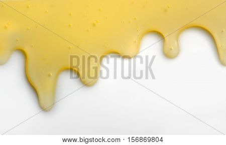 Honey liqiud flowing down on white table