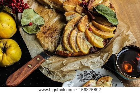 Homemade flour cake with quince and cooking utensils