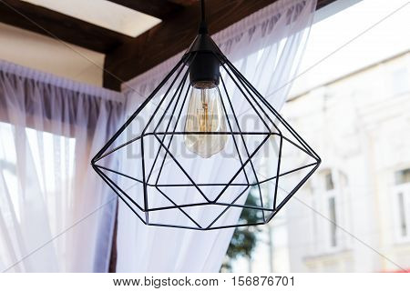 Edison's light bulb and lamp in modern style. Warm tone light bulb lamp. Lamps in coffee shop. Edison's lightbulb in interior.