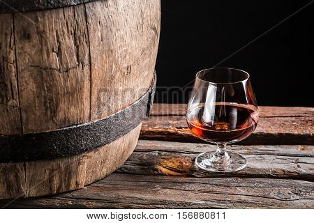 Brendy Glass And Old Wooden Barrel On Black Background